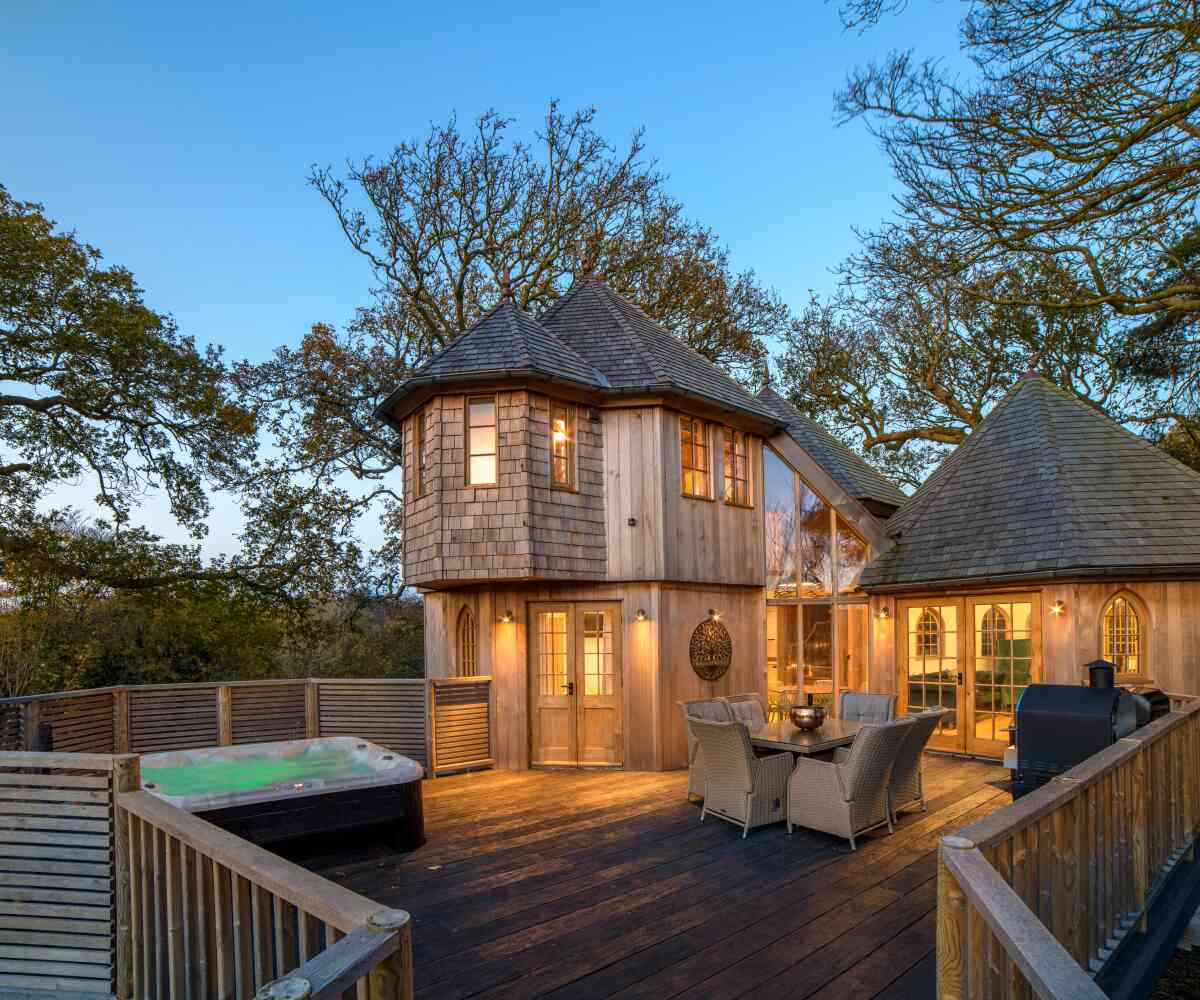 A group of animated characters from a children's show stands together, wearing colorful outfits. They are set against a backdrop of amusement park attractions, including colorful hot air balloons. The characters are smiling and appear cheerful.