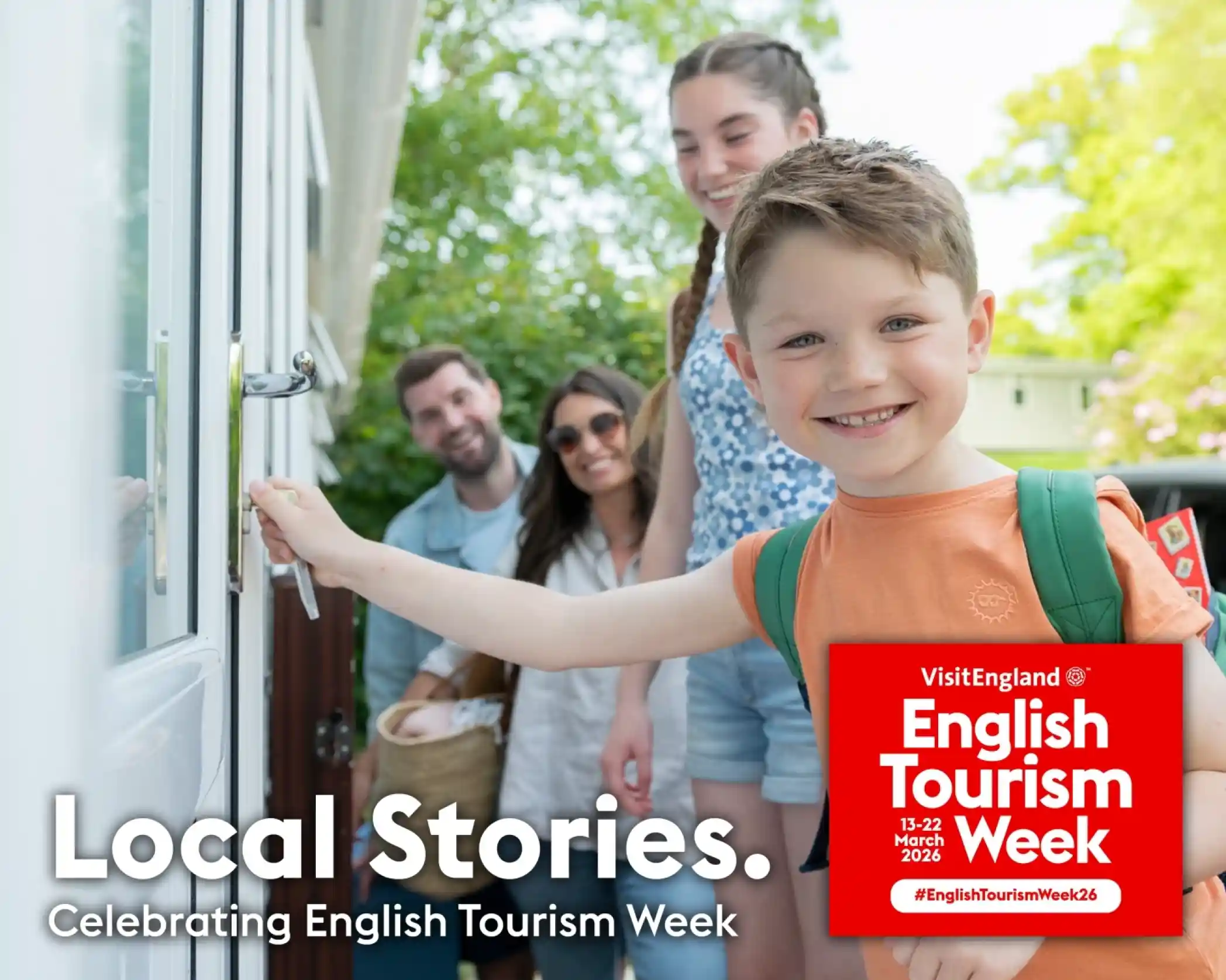A young boy unlocks a door while smiling, with a family of three standing behind him. They are enjoying a sunny day in a vibrant garden setting. The image promotes English Tourism Week, featuring a red logo and the text "Local Stories. Celebrating English Tourism Week."