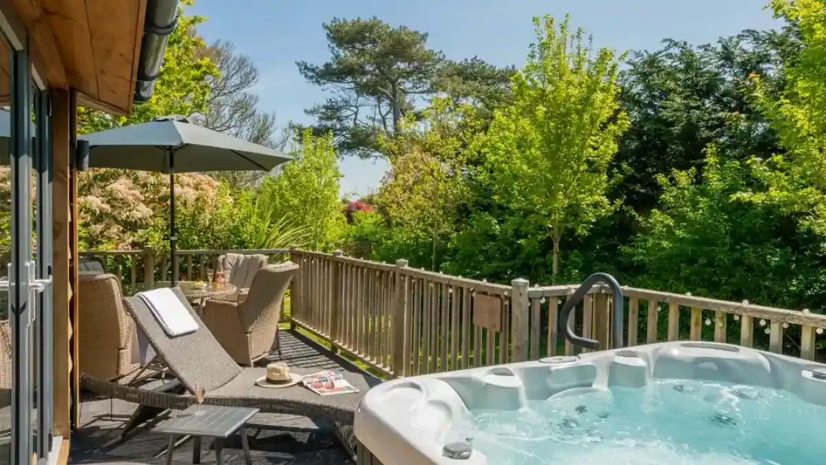 Two smiling women stand together, both wearing checkered blue shirts. One woman has long dark hair, while the other has short blonde hair and wears a black vest with the logo "SHOREFIT HOLIDAYS." They appear friendly and welcoming.