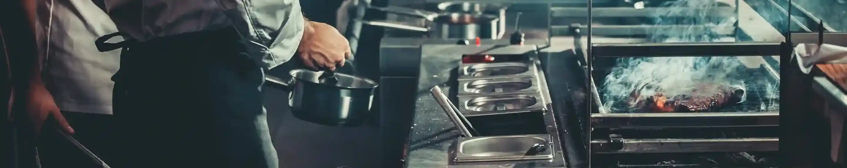 Chefs in a busy kitchen, one stirring a pot while another attends to a grill producing smoke. The scene captures a vibrant culinary environment with various cooking stations in action.