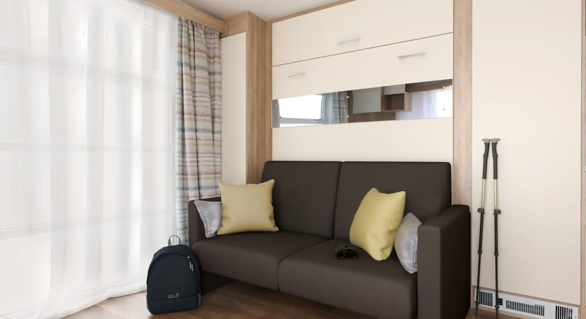 A modern living space featuring a brown sofa with yellow cushions, against a backdrop of light-colored walls and wooden accents. Next to the sofa is a black backpack and a pair of binoculars. Sheer curtains let in natural light, enhancing the cozy ambiance.
