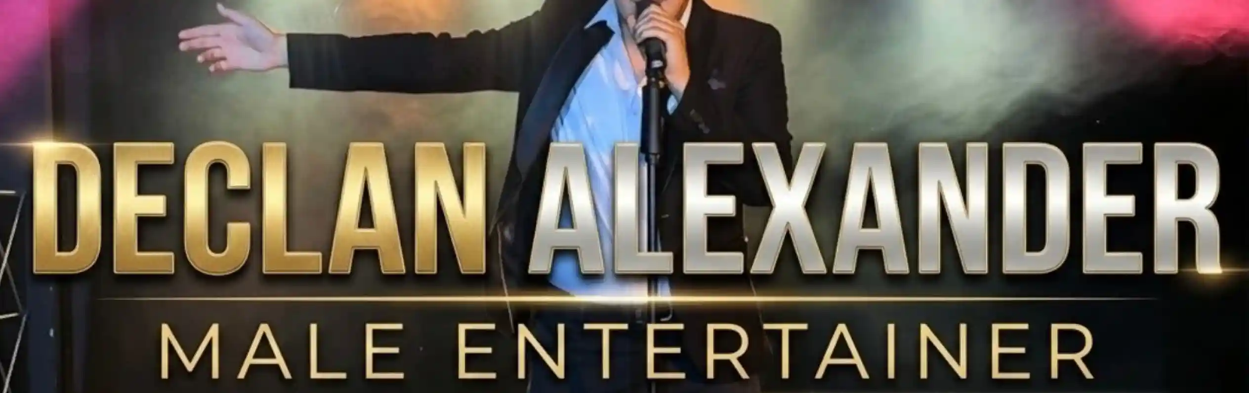 A male performer stands on stage, microphone in hand, wearing a black suit and white shirt. Colorful stage lights illuminate the background, creating a vibrant atmosphere. The text "Declan Alexander Male Entertainer" is prominently displayed.