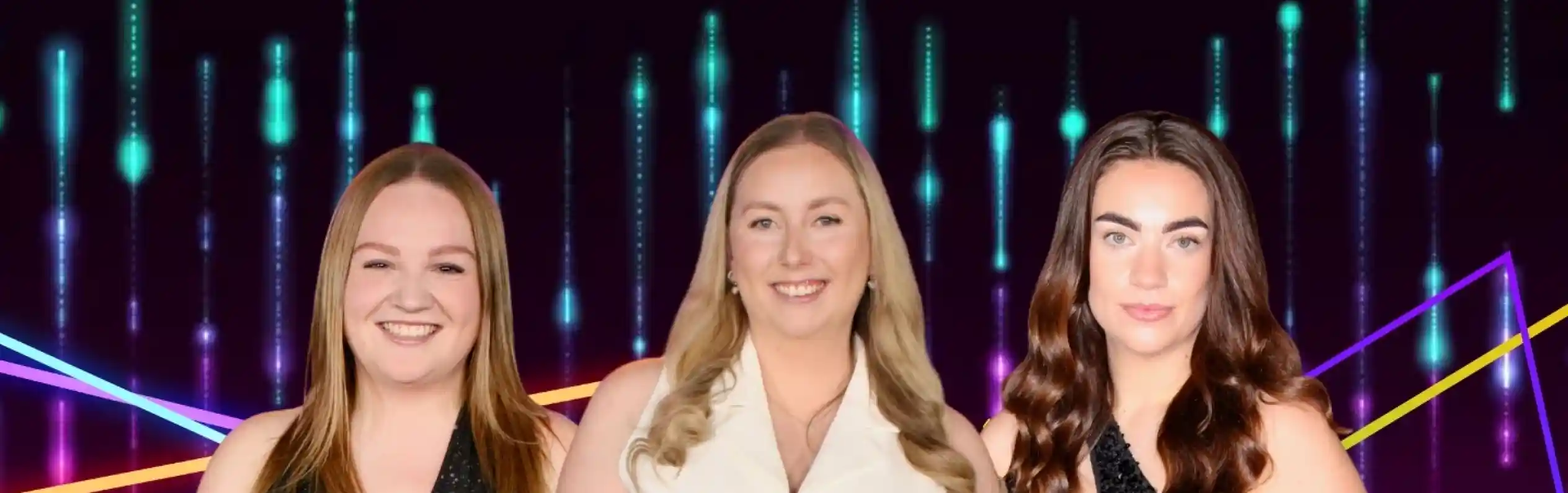 Three women stand side by side, each wearing sparkly outfits. The first woman has long, straight red hair and is in a black dress. The second woman, with long blonde hair, wears a white top and shiny green pants. The third woman has long, wavy dark hair and is dressed in a black, sparkly outfit. The background features colorful lights and patterns creating a vibrant atmosphere.