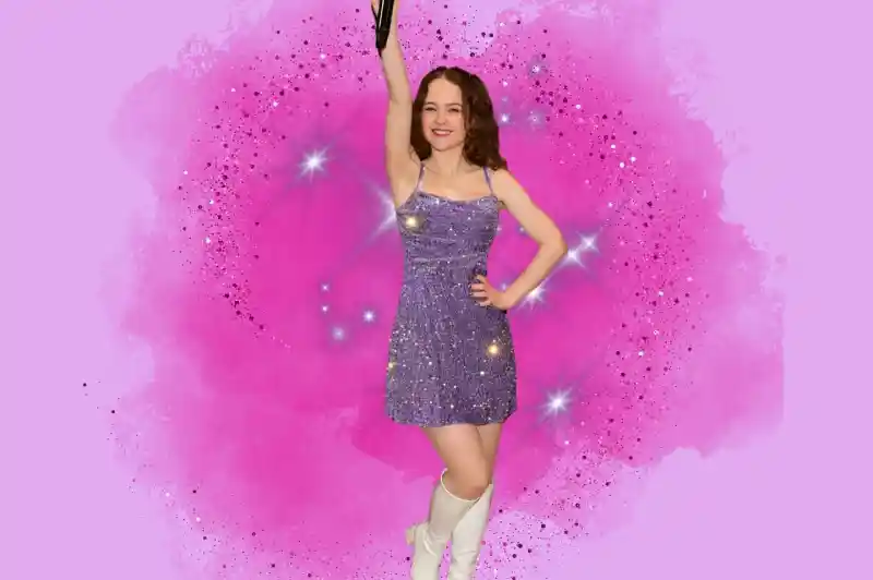 A person in a sparkling purple dress and white knee-high boots strikes a pose, holding a microphone high while surrounded by a pink, starry background.