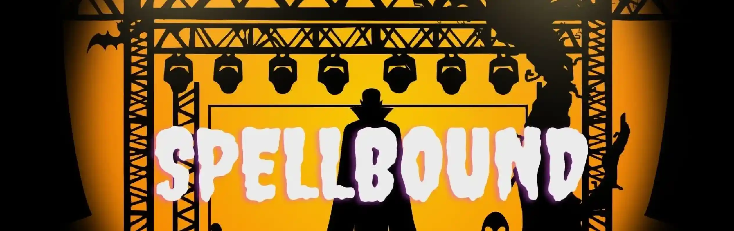 A spooky stage scene with an orange background, featuring silhouettes of a witch on a broom, a ghost, a tree with bats, and a zombie. The word "SPELLBOUND" is prominently displayed in large, whimsical letters.