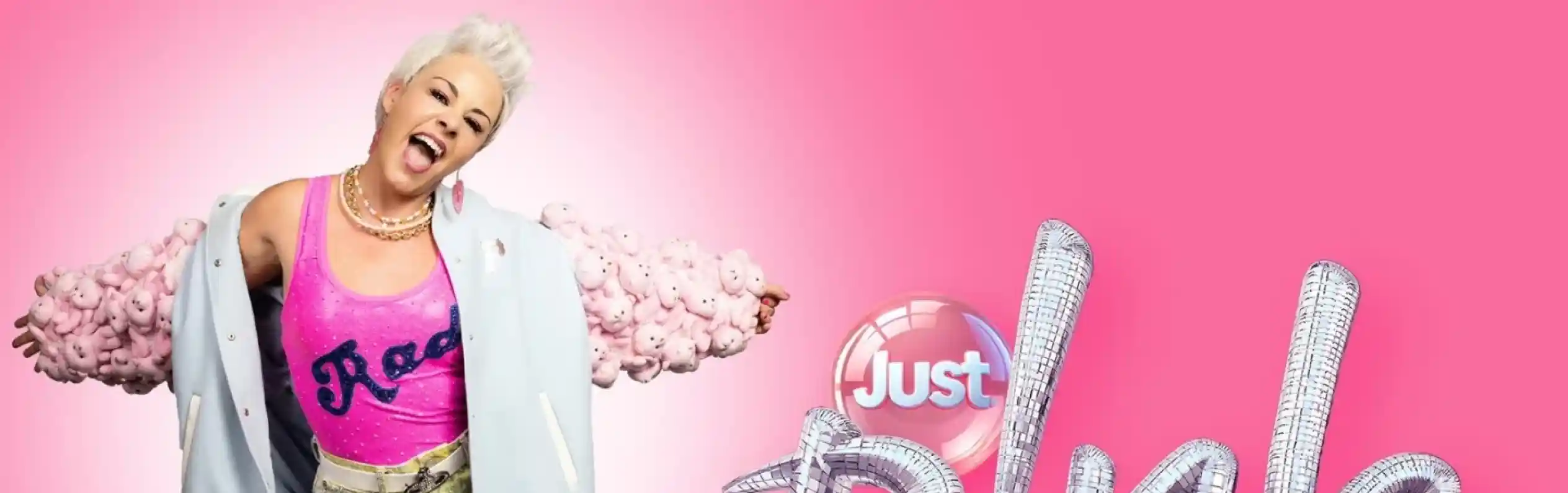 A person with short blonde hair is posing energetically in a pink-themed outfit, featuring a bright pink tank top and a light blue jacket with fluffy pink accents. They have a playful expression and are wearing pink high-top sneakers, set against a vibrant pink background with the stylized text "Just p!nk."