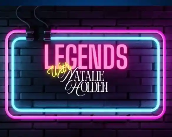 A neon sign displaying the words "Legends" in bold pink letters, with "With Natalie Holden" written in an elegant yellow script underneath, set against a dark brick background.