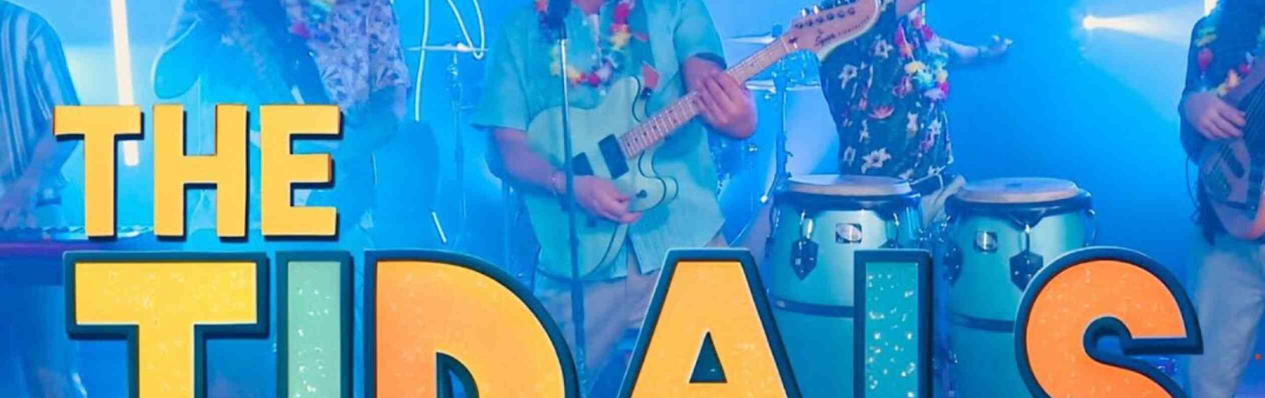 A lively band named "The Tidals" performs on stage, wearing tropical shirts and leis. They are playing various instruments, including a guitar and congas, with a vibrant blue background featuring palm trees and colorful lights.