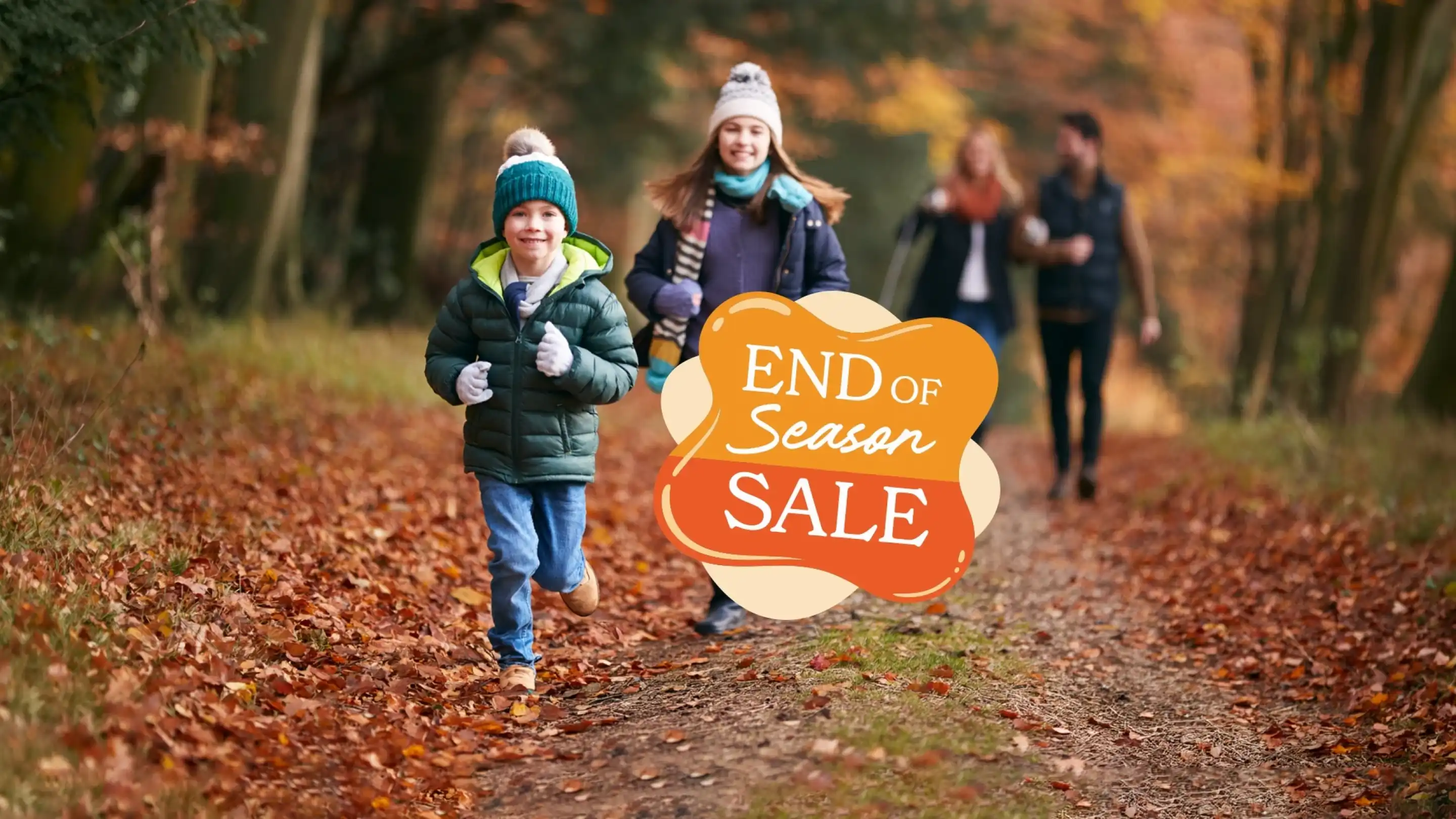 Children and adults enjoy a walk in an autumn forest, with colorful leaves on the ground. A young boy runs ahead, smiling, while others stroll in the background. Text overlay reads "End of Season Sale."