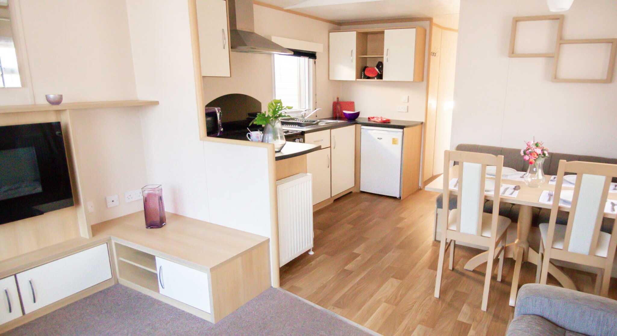 A modern kitchen and dining area with comfortable seating arrangement and a sleek table, designed for relaxation and socializing.