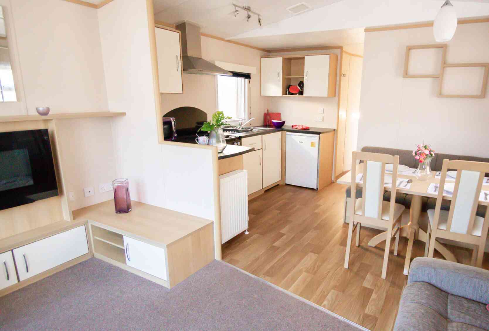 A modern kitchen and dining area with comfortable seating arrangement and a sleek table, designed for relaxation and socializing.