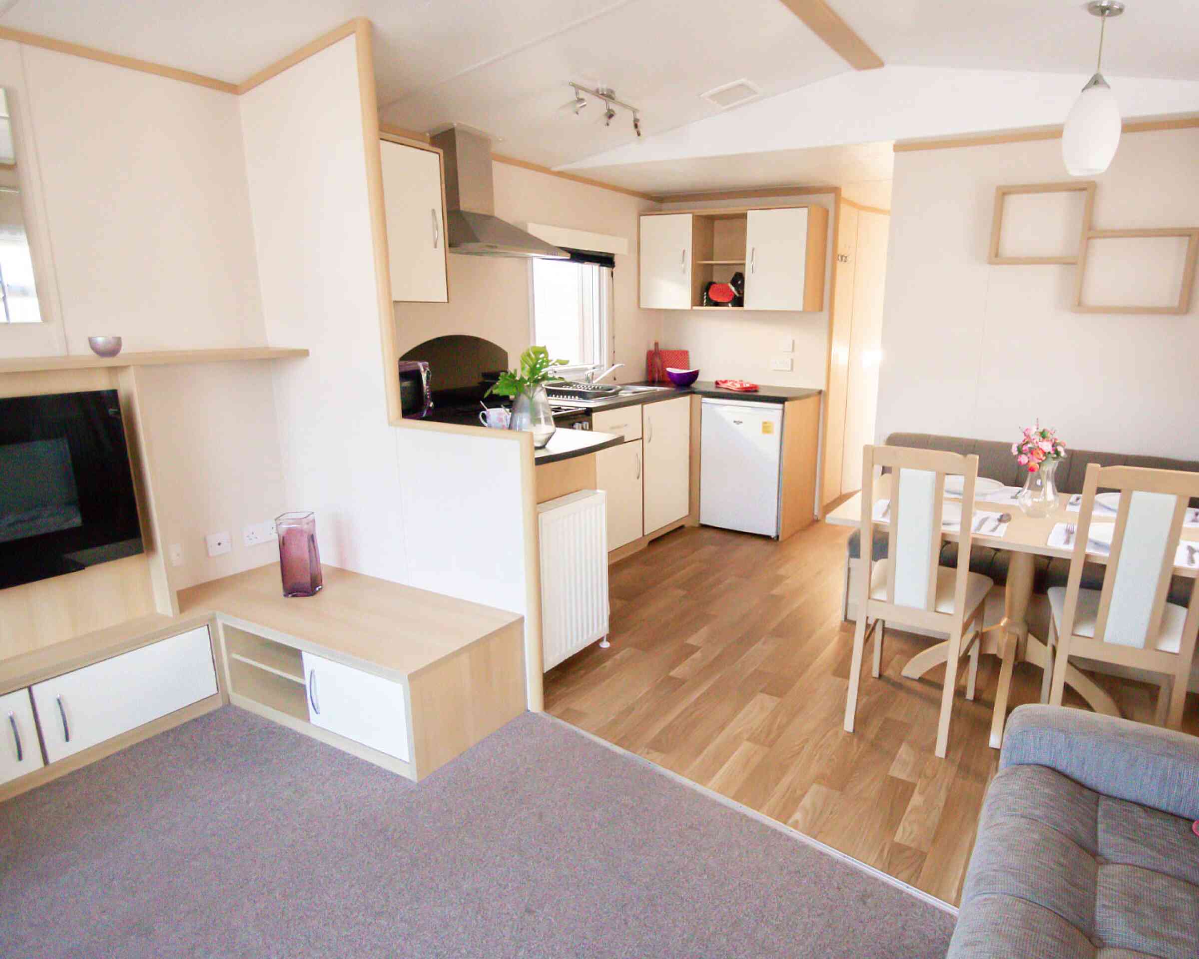 A modern kitchen and dining area with comfortable seating arrangement and a sleek table, designed for relaxation and socializing.