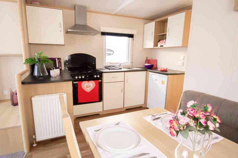 A well-equipped kitchen with a dining table, chairs, and a stove, highlighting a functional cooking space.