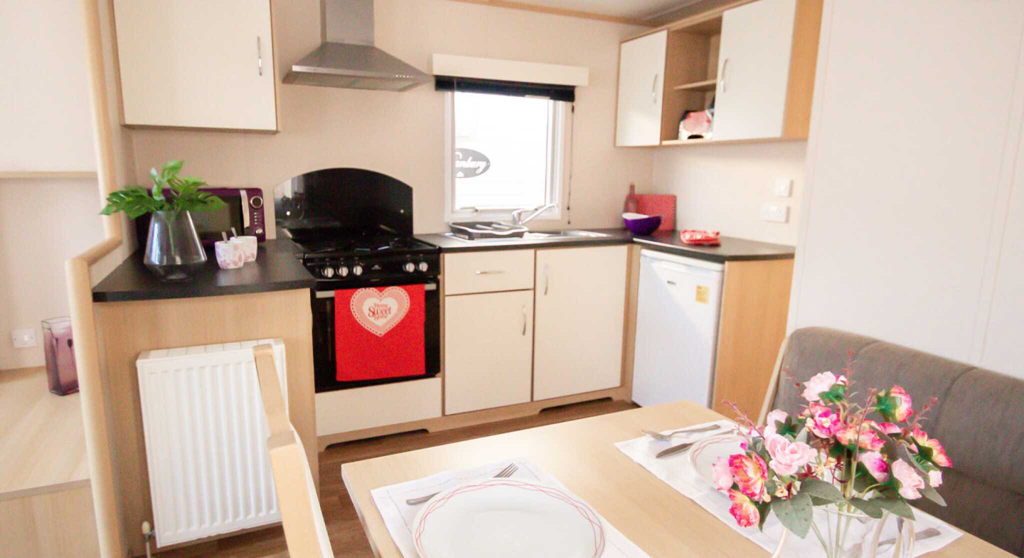 A well-equipped kitchen with a dining table, chairs, and a stove, highlighting a functional cooking space.