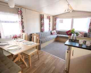 A cosy living area featuring a table surrounded by chairs, creating an inviting space for gatherings.