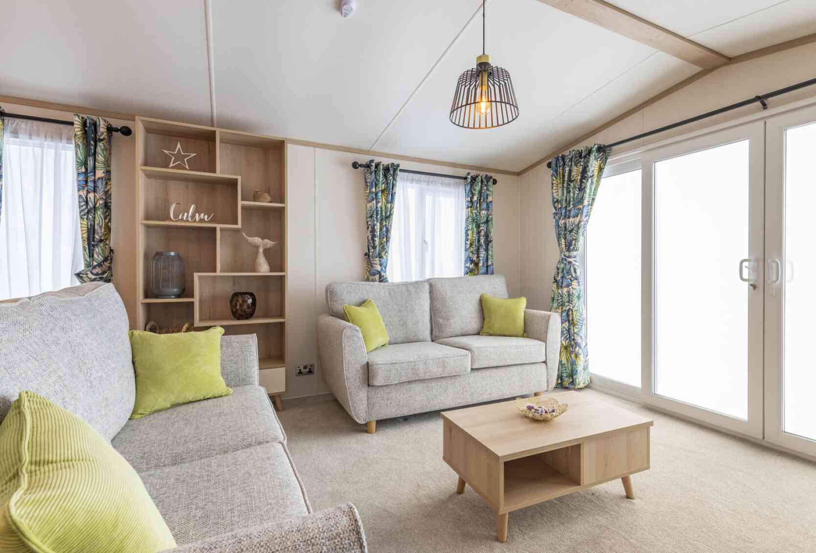 A modern living room with a comfortable couches, a coffee table, and a storage unit in a stylish arrangement.