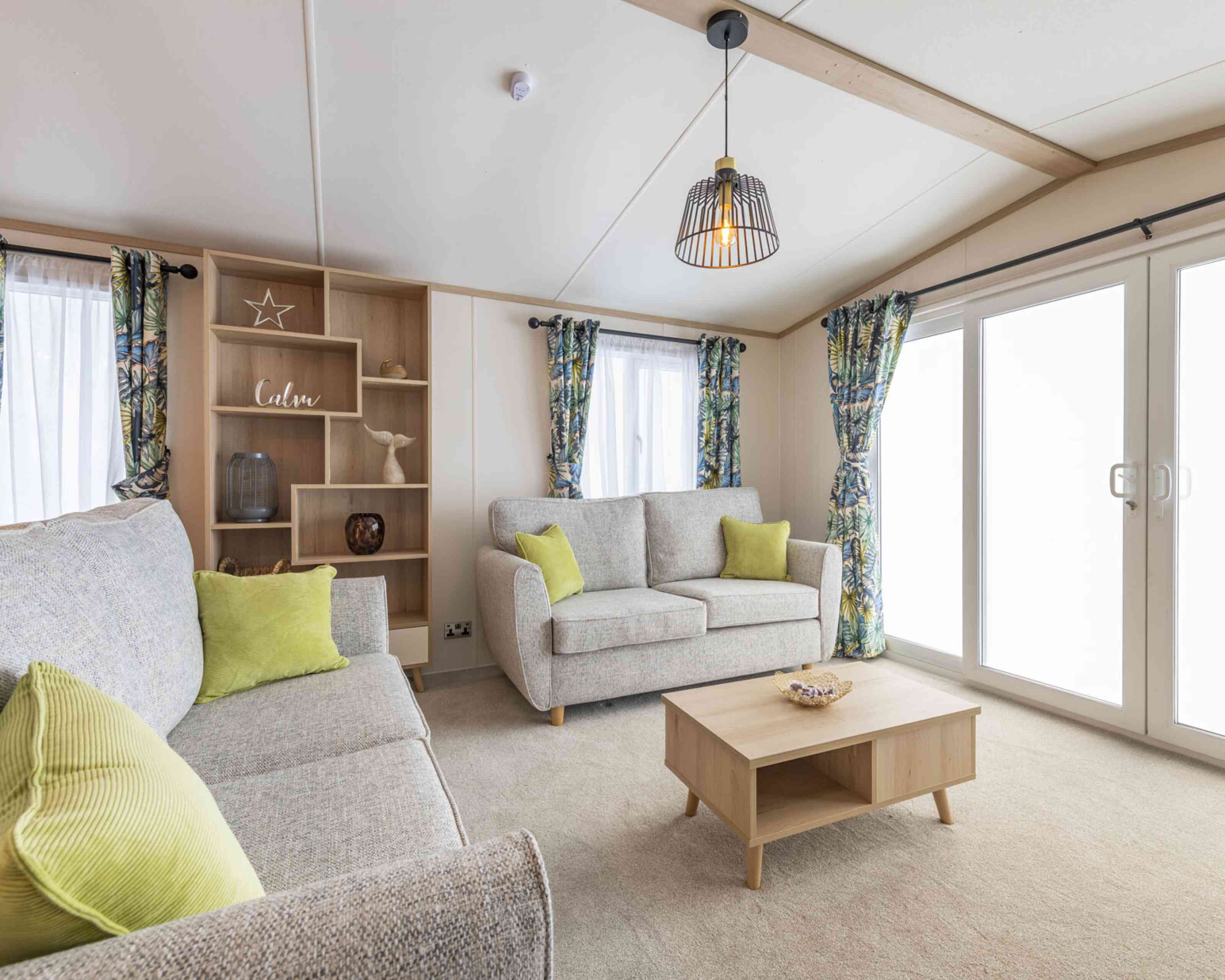 A modern living room with a comfortable couches, a coffee table, and a storage unit in a stylish arrangement.