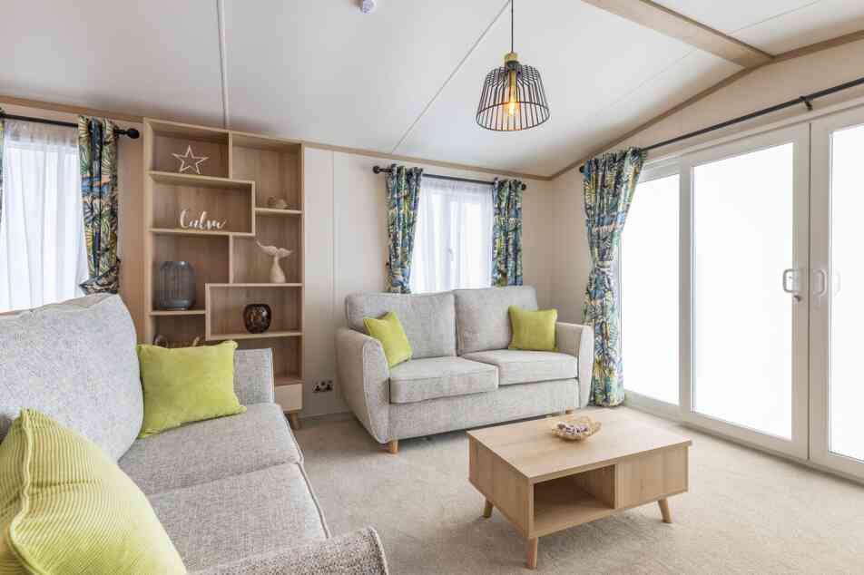 A modern living room with a comfortable couches, a coffee table, and a storage unit in a stylish arrangement.