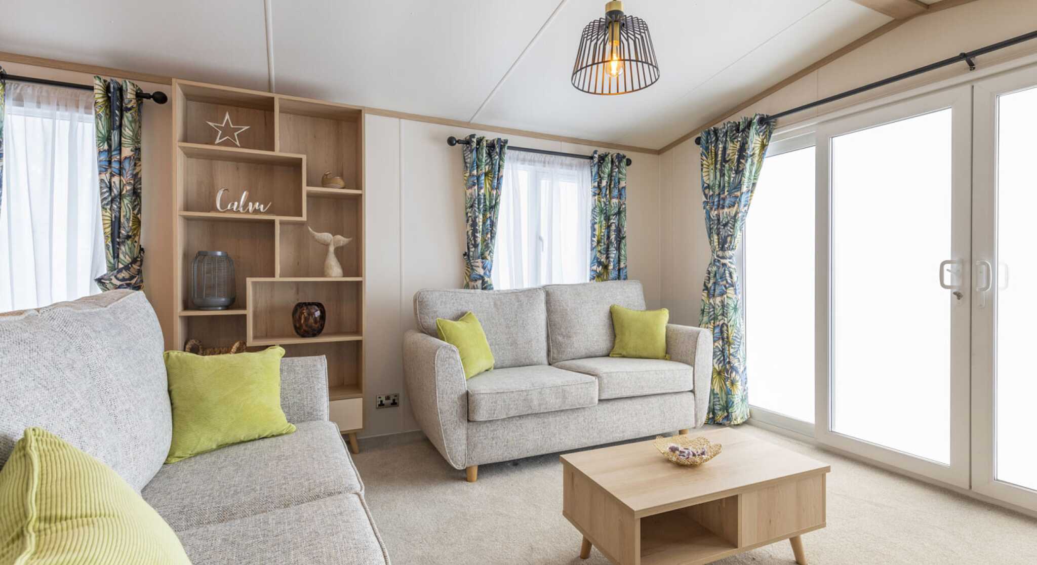 A modern living room with a comfortable couches, a coffee table, and a storage unit in a stylish arrangement.