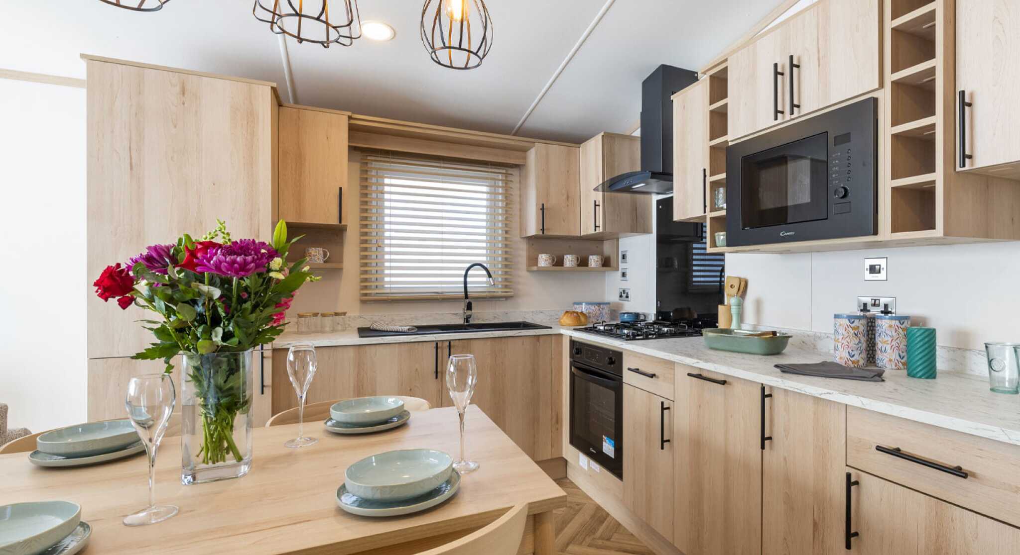 A kitchen featuring wooden cabinets and a dining table, creating a warm and inviting atmosphere.