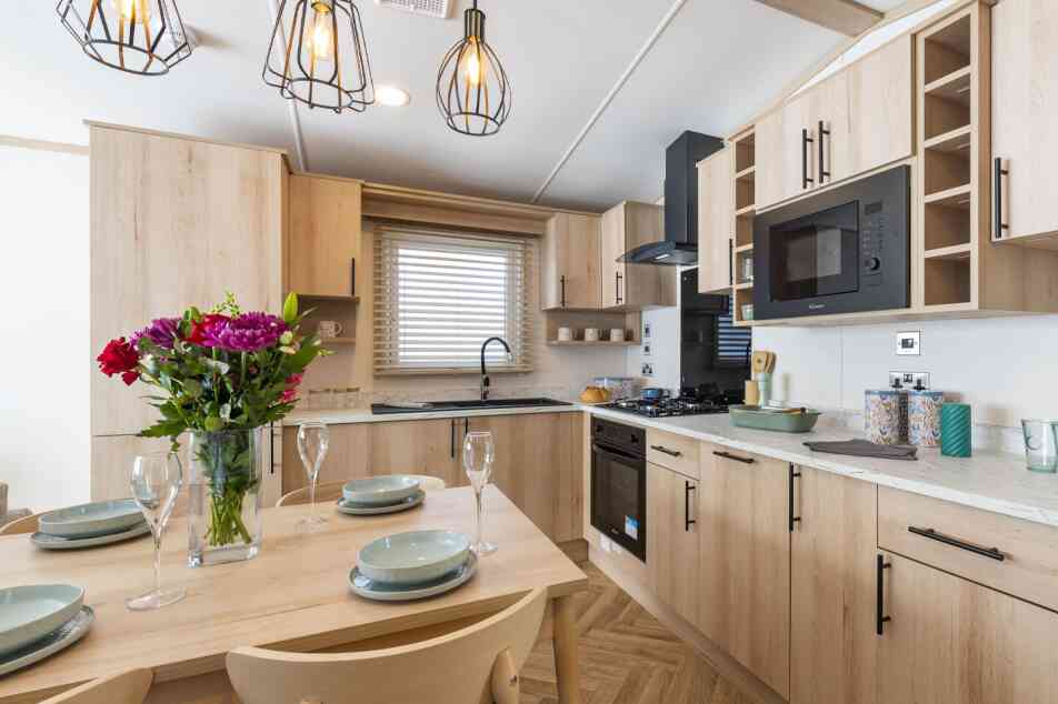 A kitchen featuring wooden cabinets and a dining table, creating a warm and inviting atmosphere.