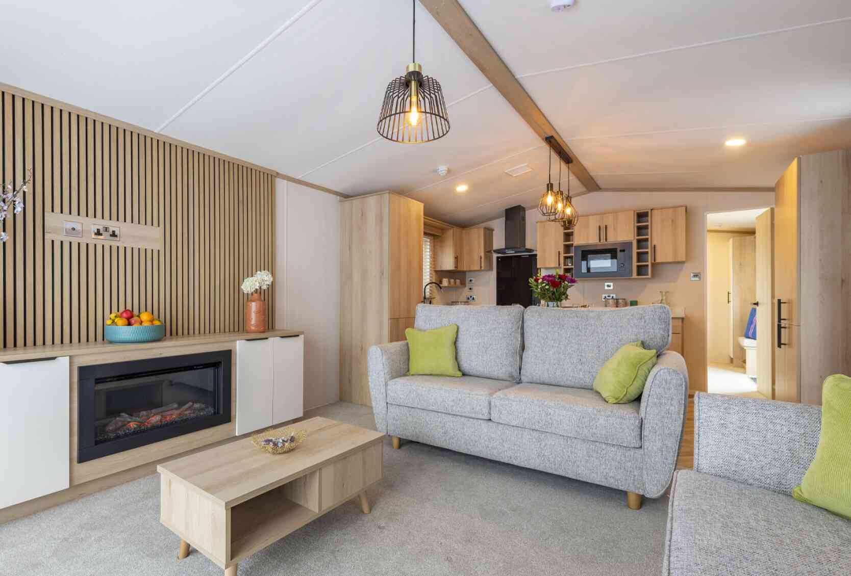 A modern living room showcasing a couch, coffee table, and a fireplace, designed for comfort and socializing