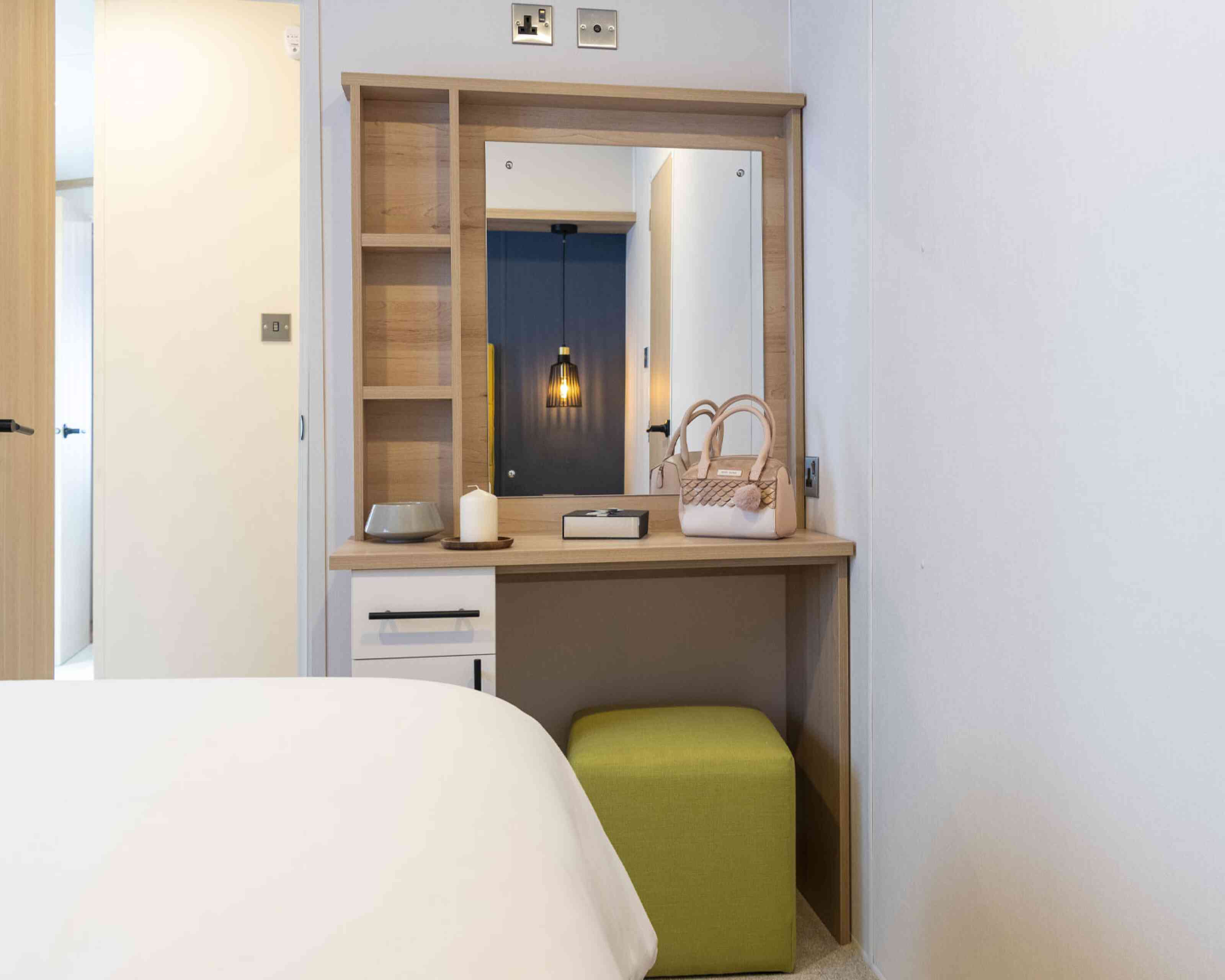 Master bedroom showcasing a bed, a dressing table, and a vanity mirror