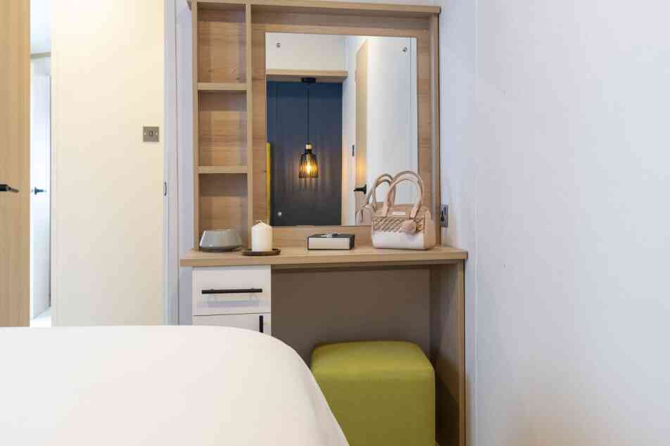 Master bedroom showcasing a bed, a dressing table, and a vanity mirror