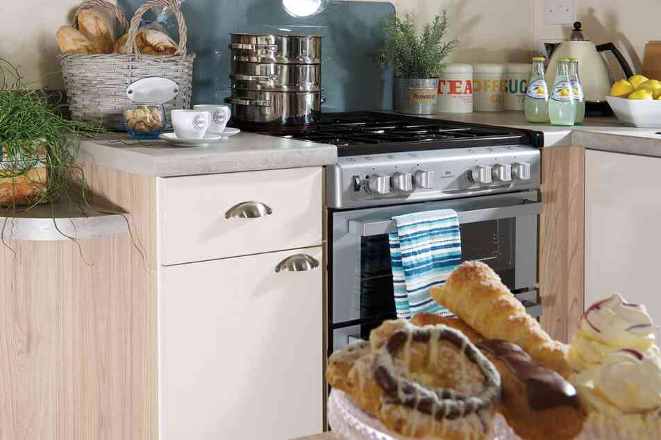 A kitchen equipped with a stove and oven, and a dining table holding a plate of food for a meal.