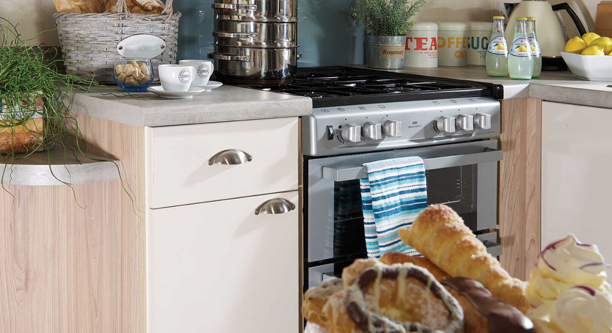 A kitchen equipped with a stove and oven, and a dining table holding a plate of food for a meal.