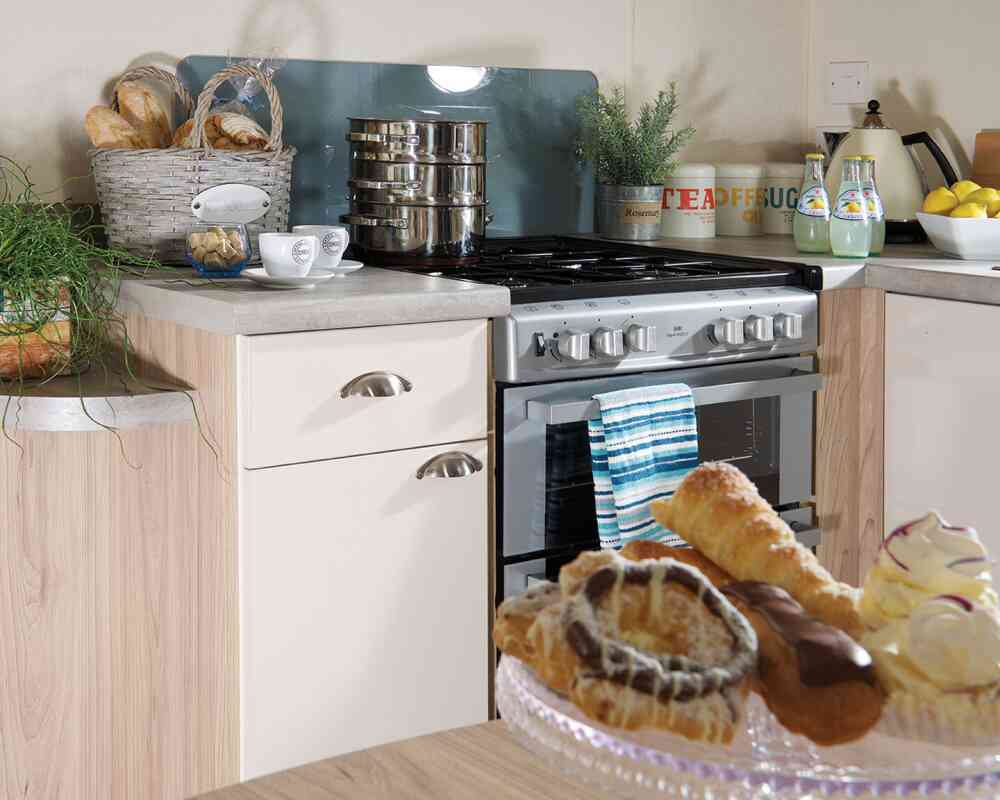 A kitchen equipped with a stove and oven, and a dining table holding a plate of food for a meal.