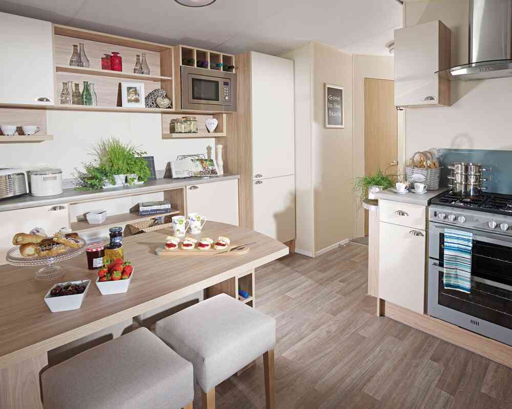 A cosy kitchen with a dining table and four chairs, showcasing cabinets and kitchenware in the surrounding area.