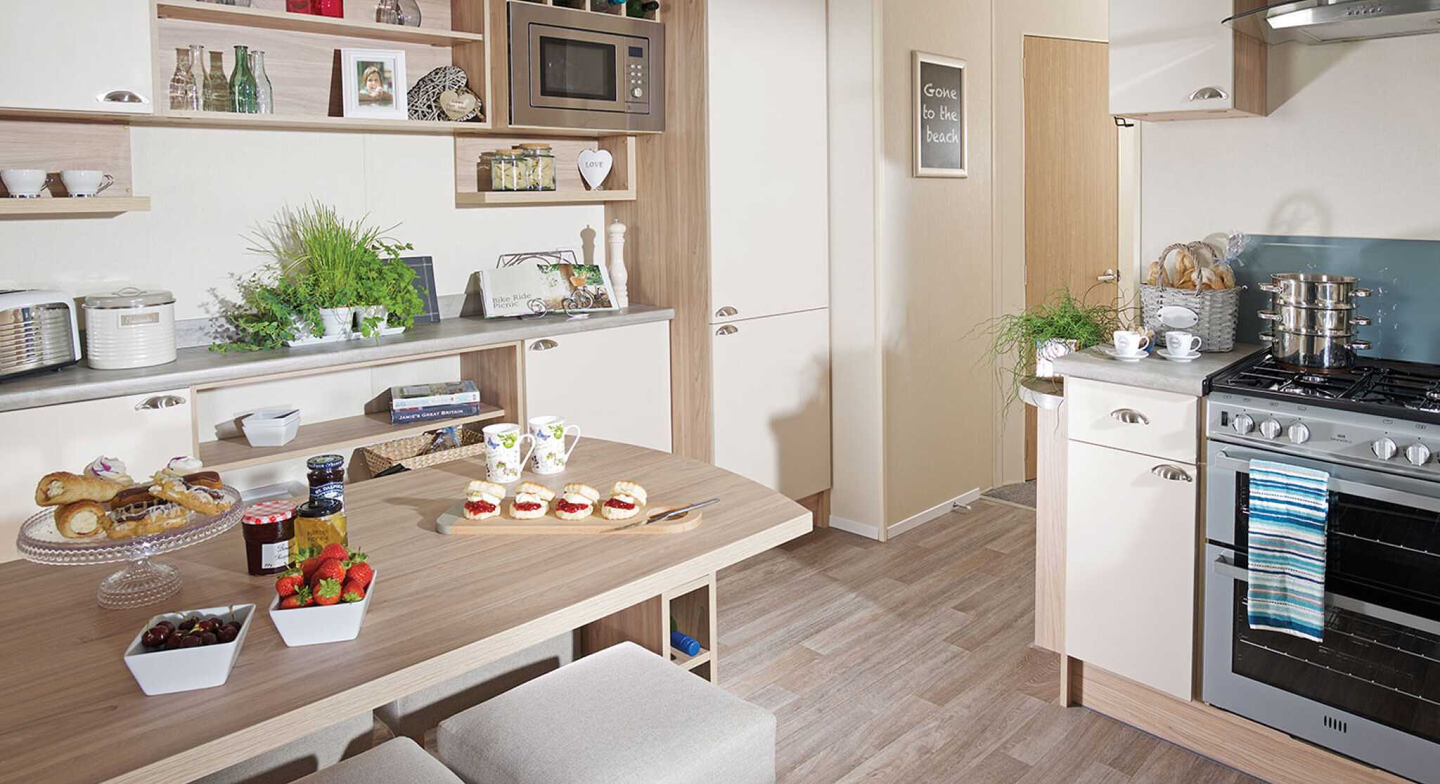 A cosy kitchen with a dining table and four chairs, showcasing cabinets and kitchenware in the surrounding area.
