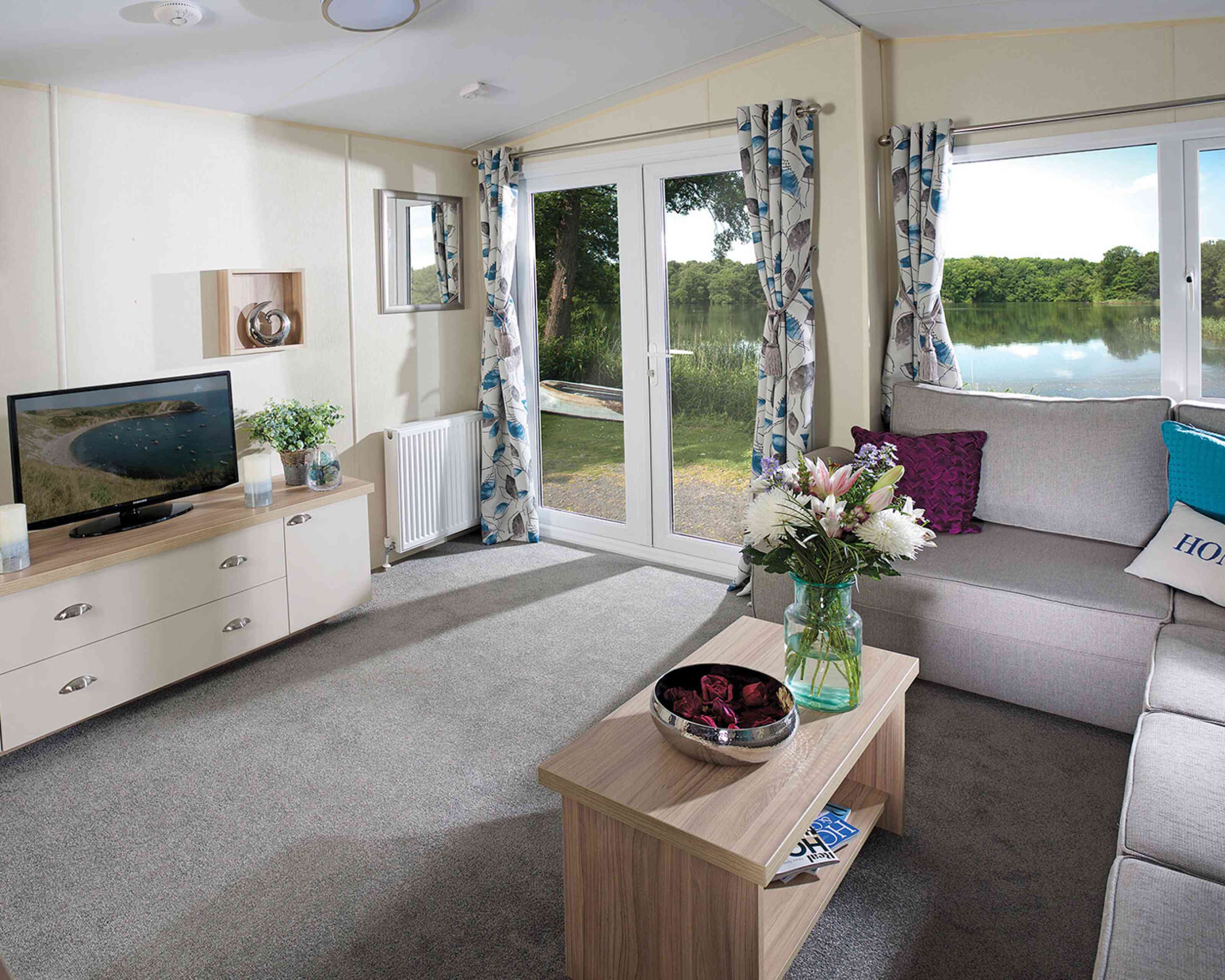 A stylish living room showcasing a couch, a coffee table, and a television, creating a welcoming atmosphere.