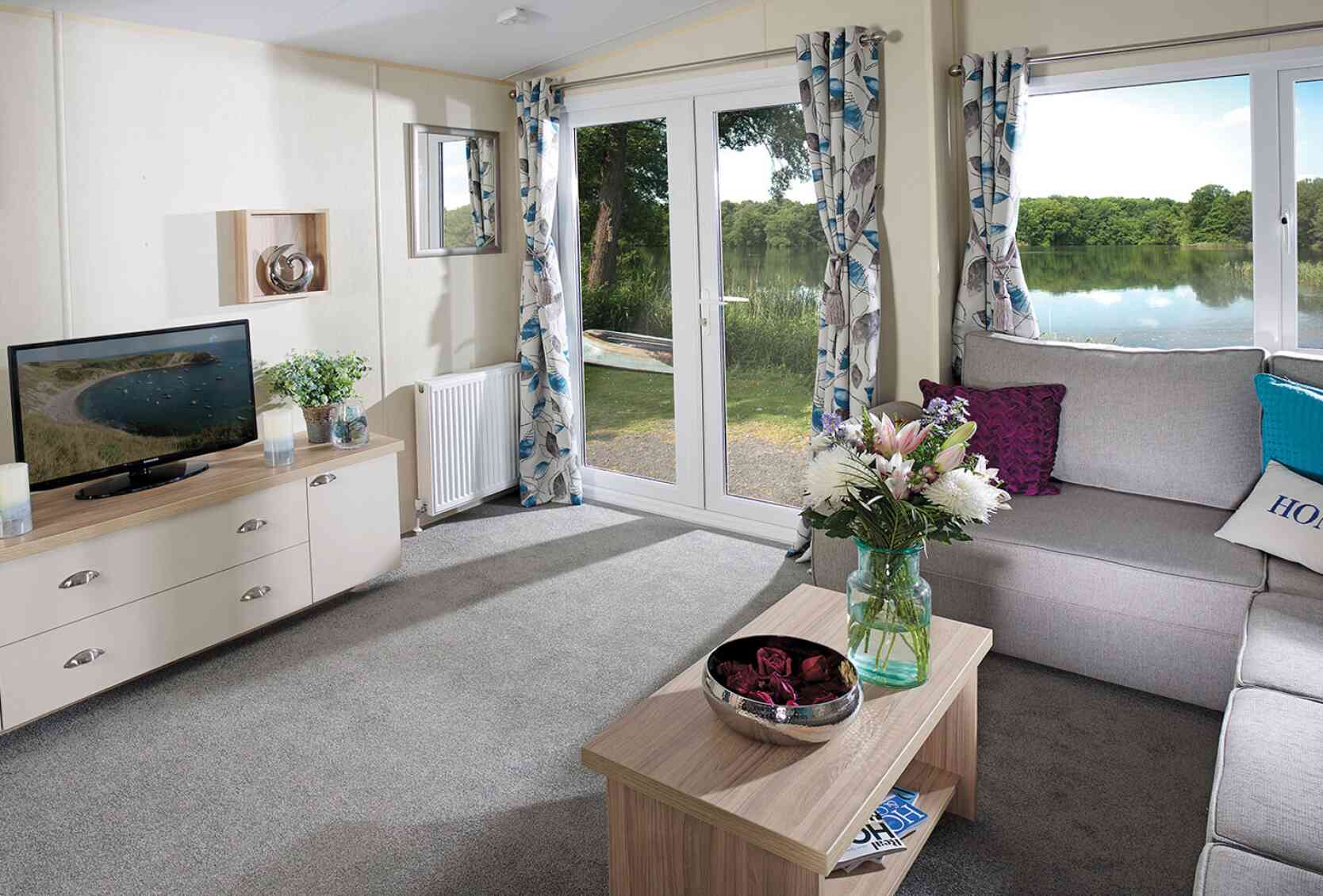 A stylish living room showcasing a couch, a coffee table, and a television, creating a welcoming atmosphere.