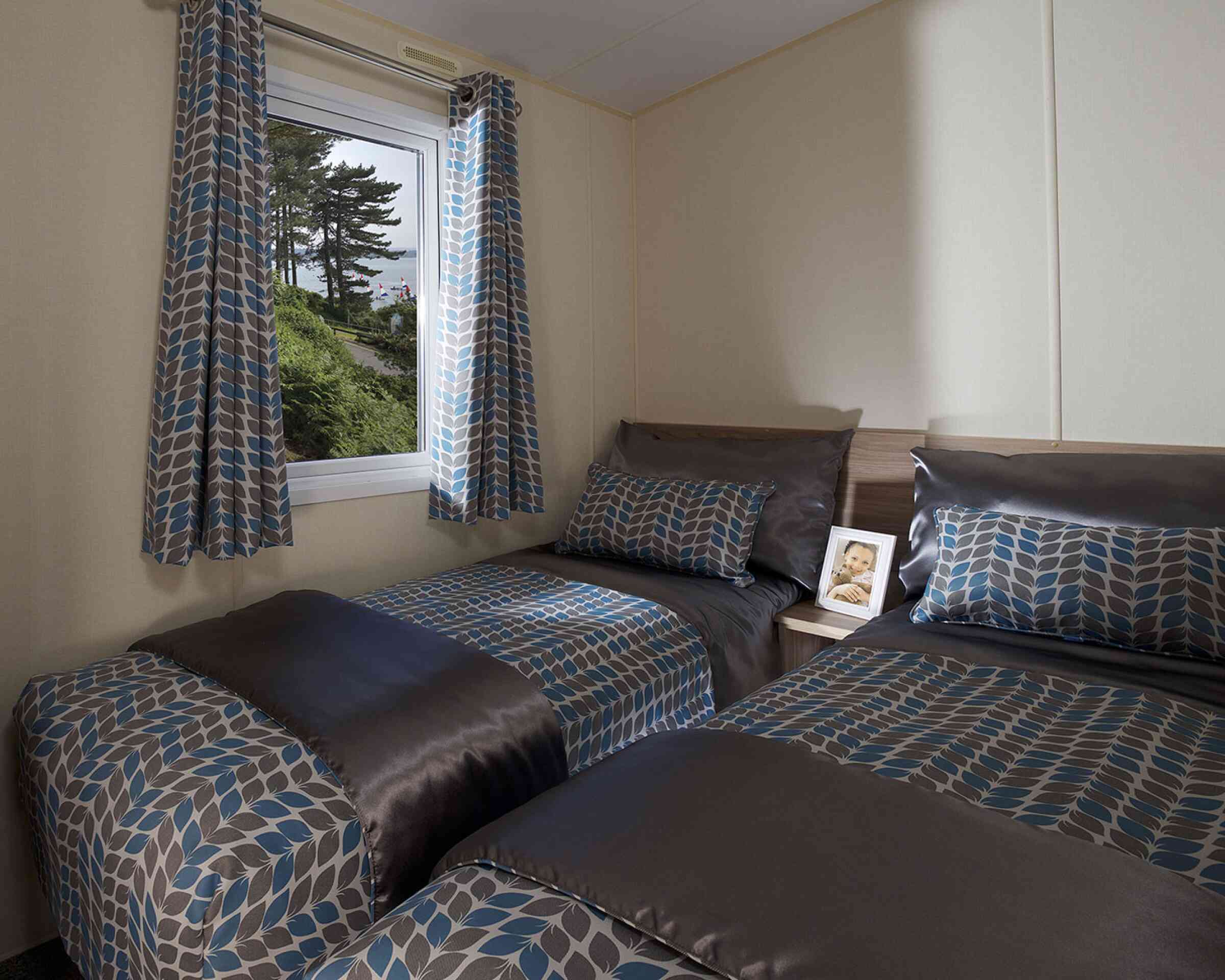 A bedroom featuring two beds and a window that offers a beautiful view of the outdoors.