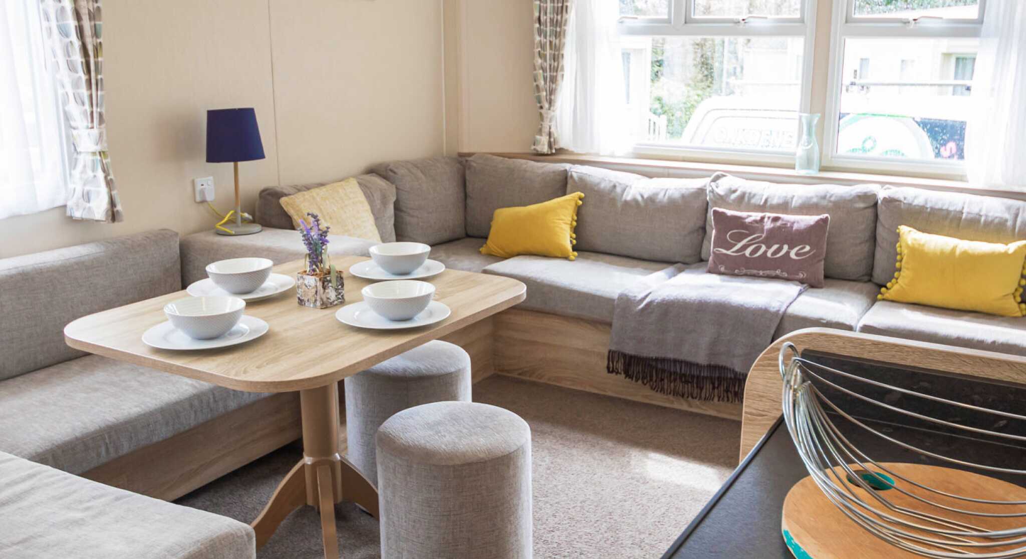 A stylish living room showcasing couches, various tables, and a coffee table, designed for comfort and conversation.