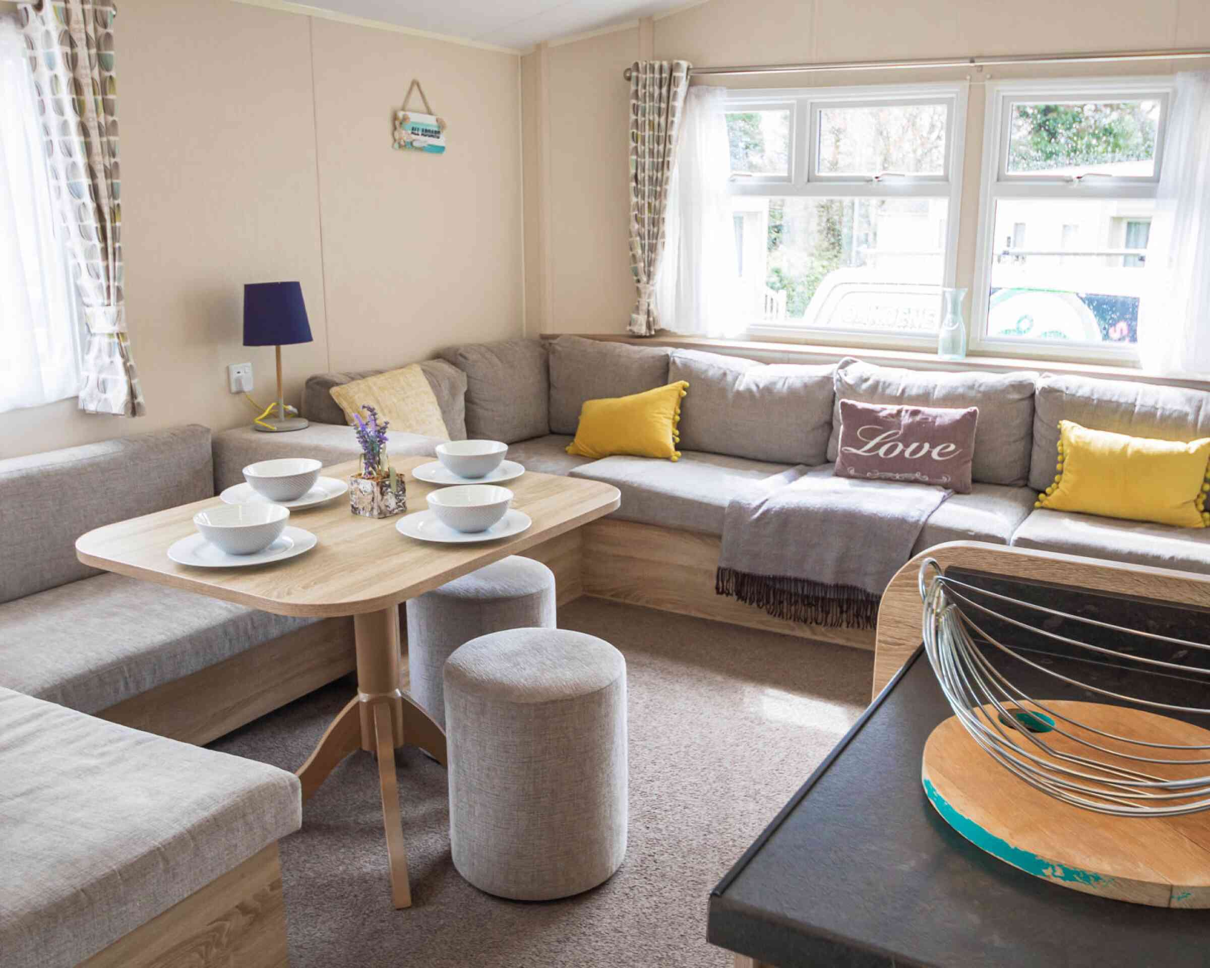 A stylish living room showcasing couches, various tables, and a coffee table, designed for comfort and conversation.