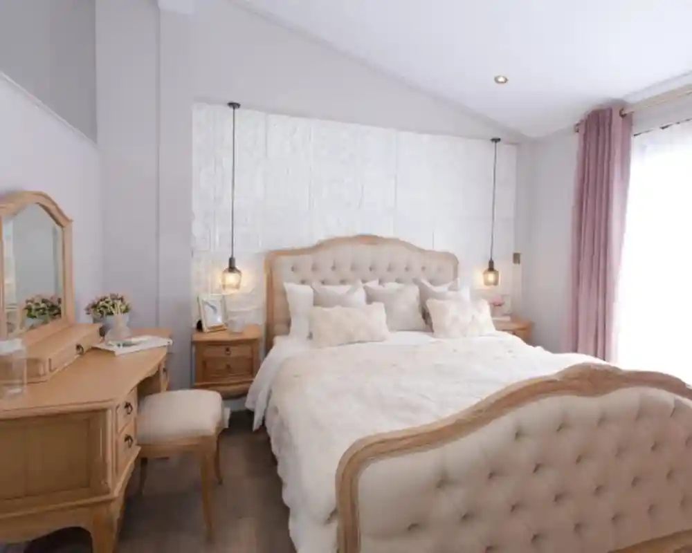 Elegant bedroom with a tufted cream bed, wooden vanity, and plush pink curtains.