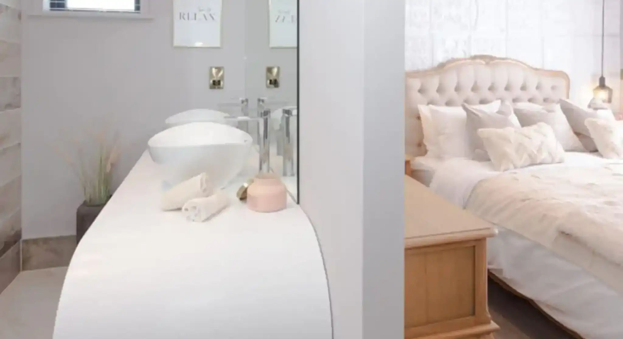 Interior view of a modern bathroom vanity area with two sinks and a glimpse of a tufted headboard bedroom.