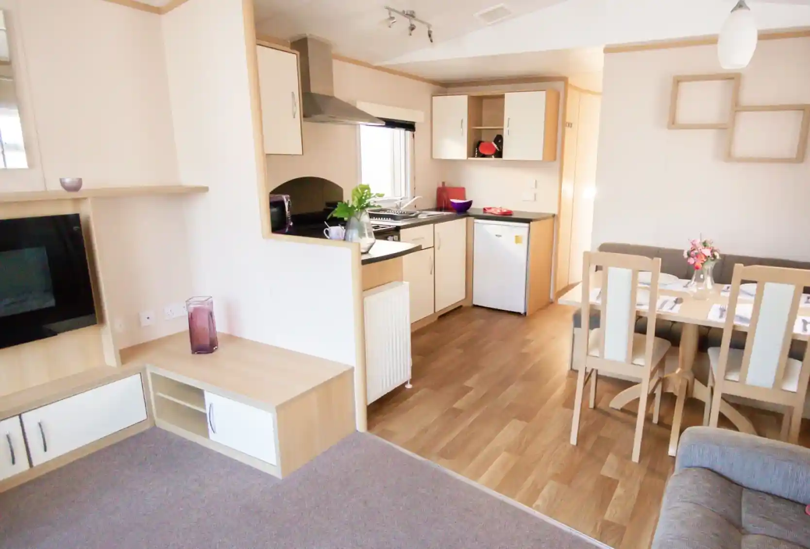 A modern kitchen and dining area with comfortable seating arrangement and a sleek table, designed for relaxation and socializing.