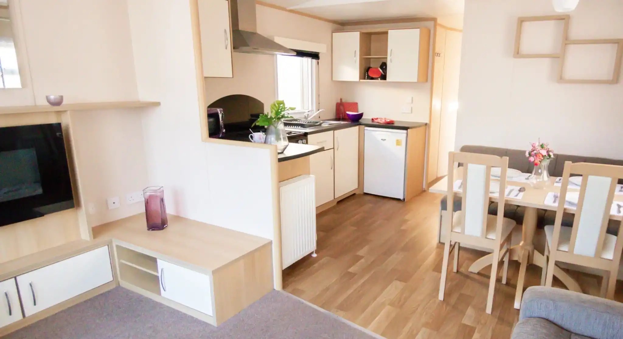 A modern kitchen and dining area with comfortable seating arrangement and a sleek table, designed for relaxation and socializing.