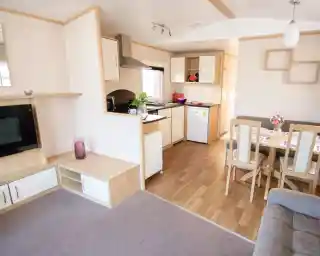 A modern kitchen and dining area with comfortable seating arrangement and a sleek table, designed for relaxation and socializing.