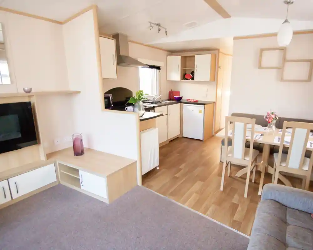 A modern kitchen and dining area with comfortable seating arrangement and a sleek table, designed for relaxation and socializing.