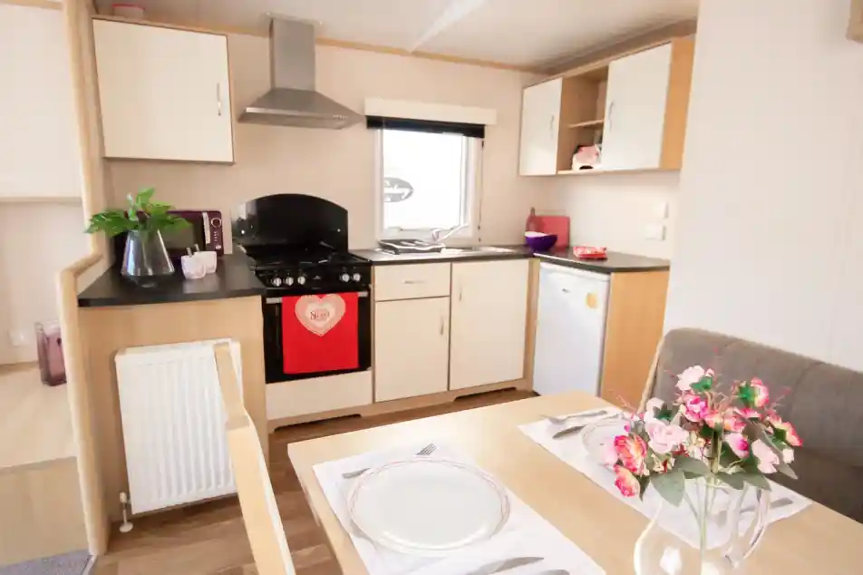 A well-equipped kitchen with a dining table, chairs, and a stove, highlighting a functional cooking space.