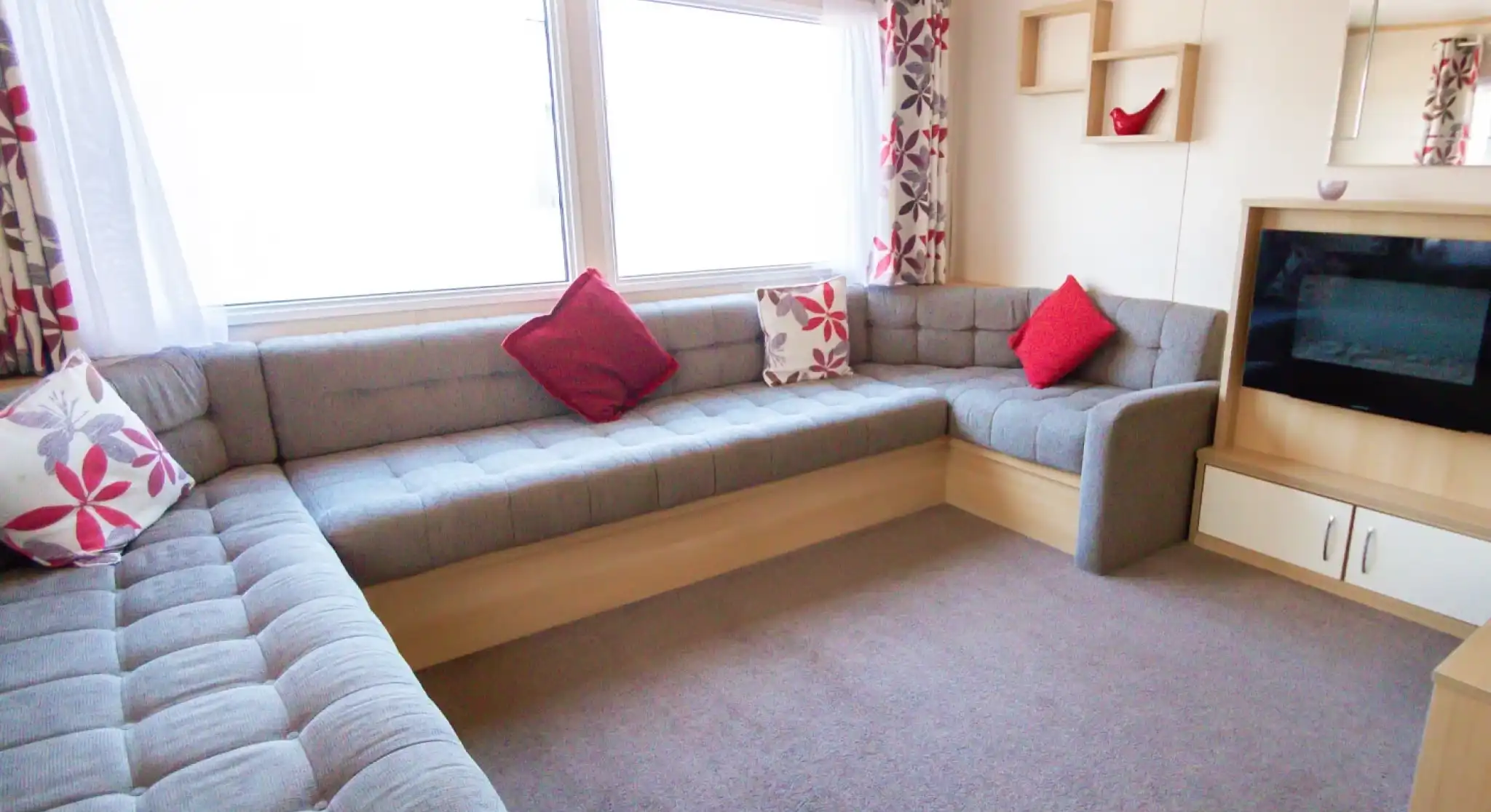 A stylish living room with a couch, a television, and a coffee table, designed for leisure and socializing.