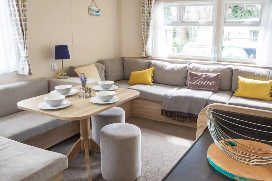 A stylish living room showcasing couches, various tables, and a coffee table, designed for comfort and conversation.