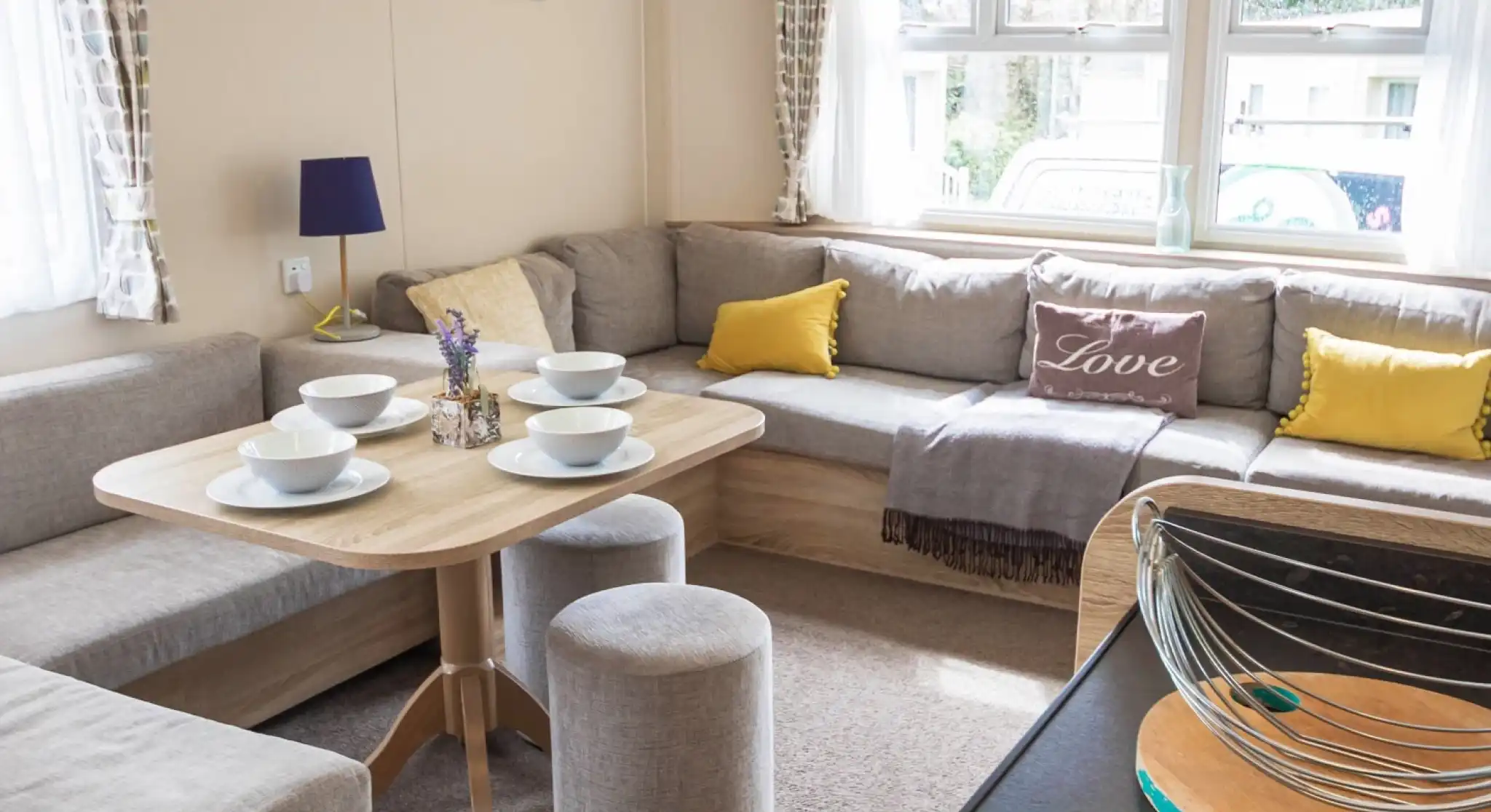 A stylish living room showcasing couches, various tables, and a coffee table, designed for comfort and conversation.