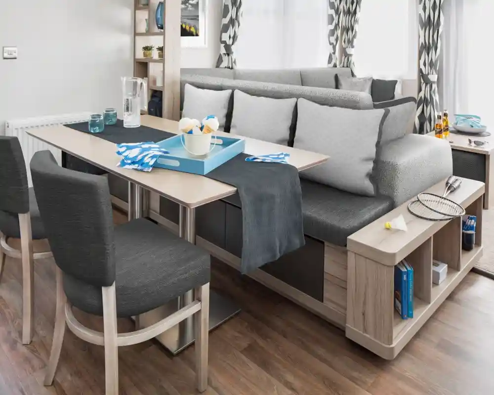 Modern dining area with a dining table, bench seating and integrated shelving.