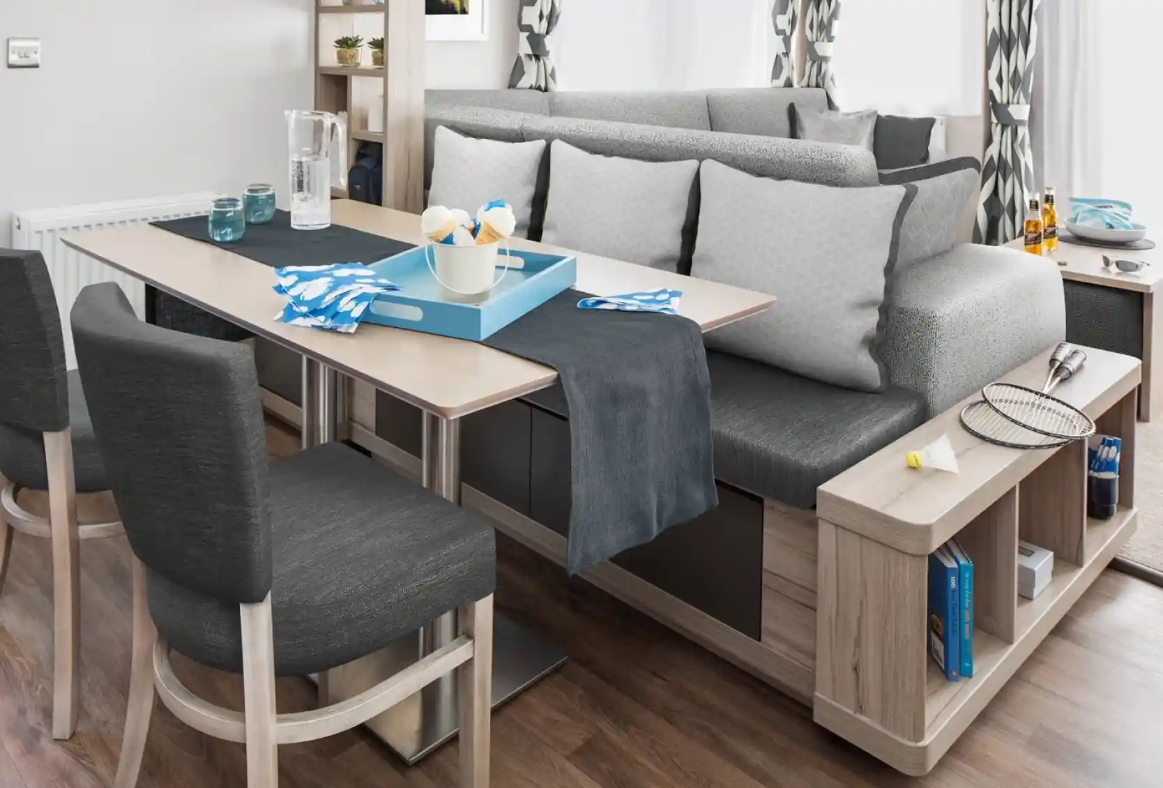 Modern dining area with a dining table, bench seating and integrated shelving.